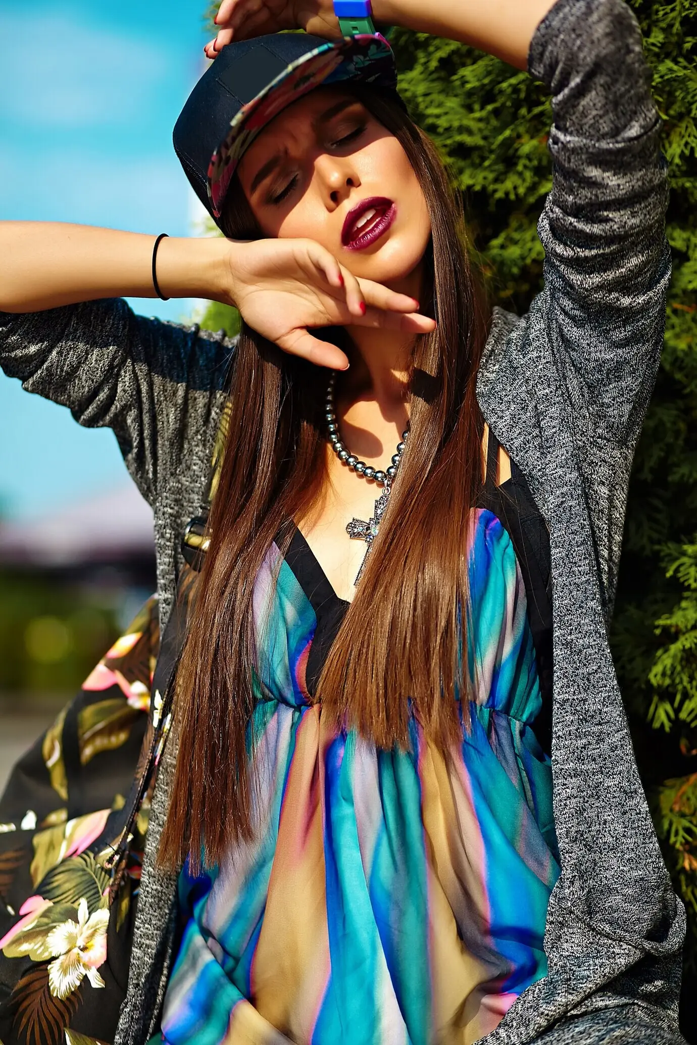 Schöne junge brünette Frau, ein Model, modisch und stilvoll, in sommerlicher, hipsterhafter, farbenfroher, lässiger Kleidung, die auf der Straße posiert.